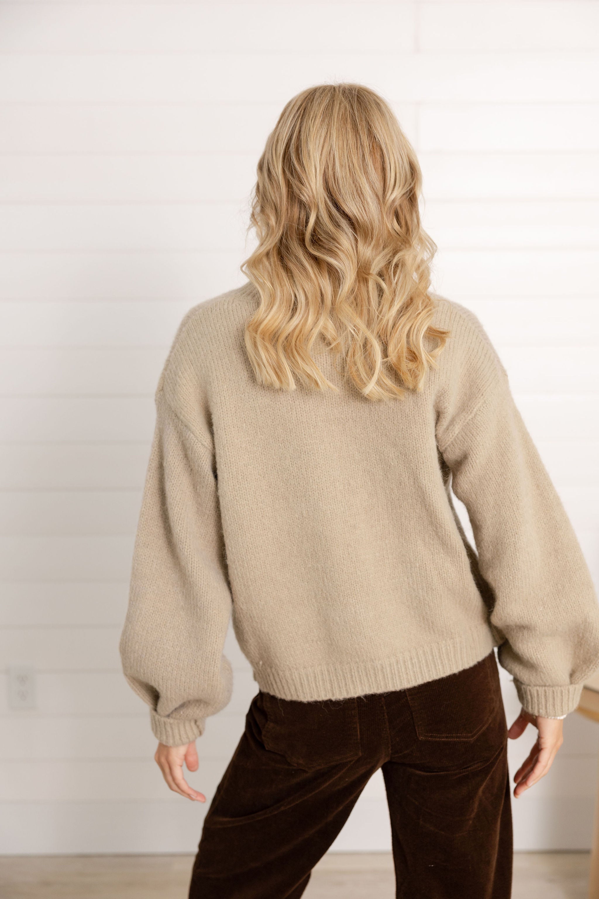 woman showing the back of the tie front sweater