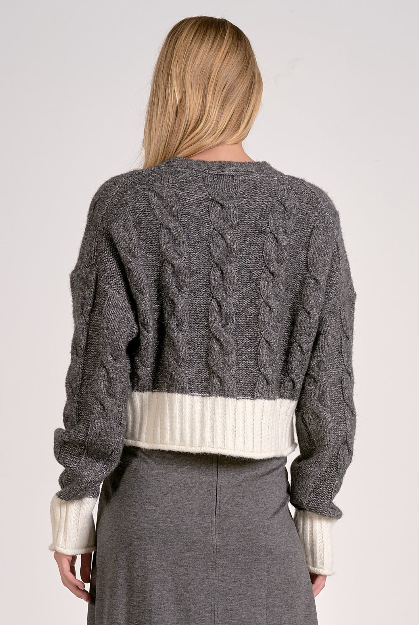 Back view of the Grey and white two-tone cropped v-neck cardigan with cable knit and button front