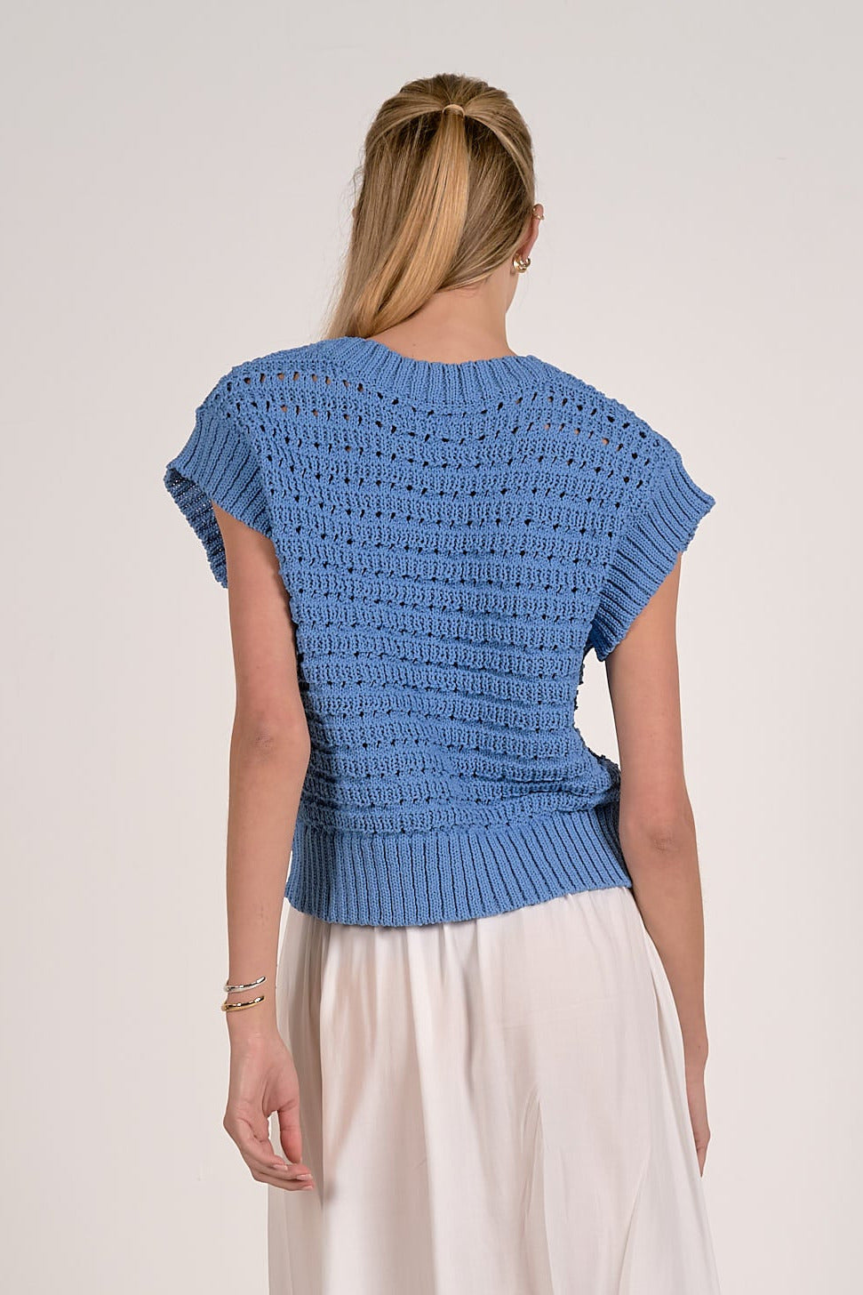back of vibrant blue textured open knit cap sleeve sweater with ribbed trim
