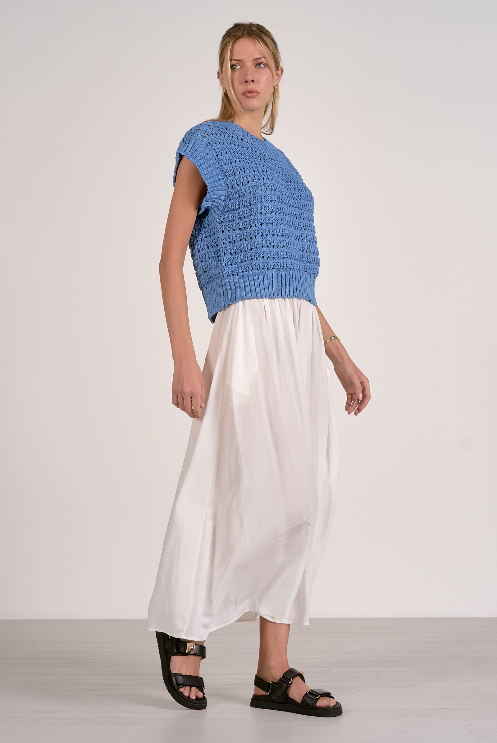 Vibrant blue textured open knit cap sleeve sweater with ribbed trim shown with white skirt and sandals
