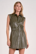 Woman wearing a pine faux leather elastic waist short dress with collared neckline and snap front