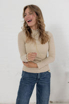 woman wearing the lettuce edge detail fitted mock neck top in almond