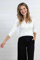 Woman modeling the ivory Mac and Me ruched front button down top