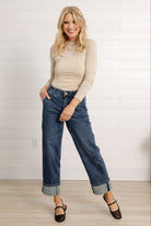 Model from Mainstream Boutique wearing a pair of the Mac and Me Boyfriend Jeans along with a cream long sleeve mock neck and black mary jane mesh shoes.