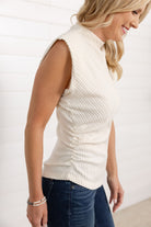 Woman wearing the funnel neck top by Mac and Me in the color, french vanilla.  Shirt shows the side details of the top that include ruched sides and perfectly designed ribbing to create a slimming effect.  