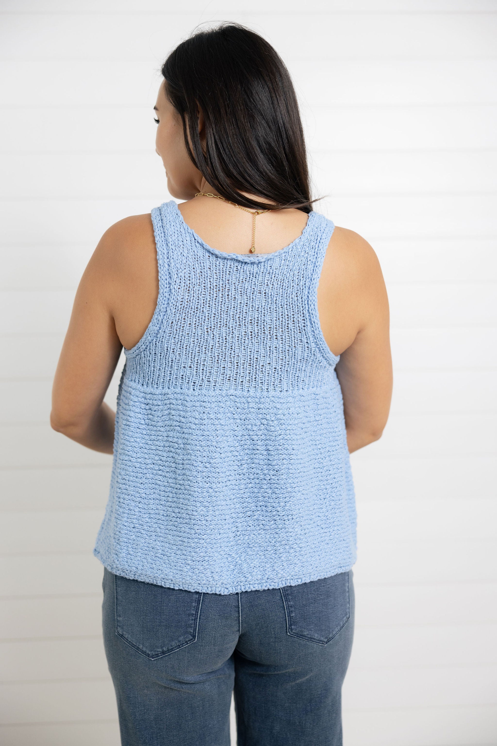 woman modeling the back of mac and me swing sweater top in light blue