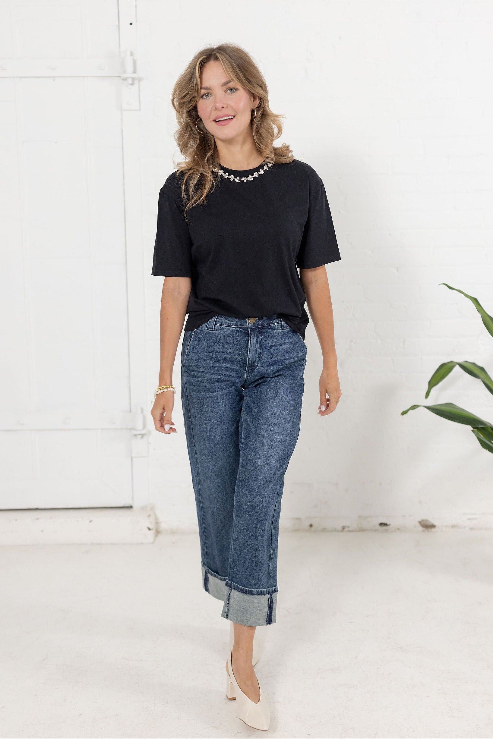 Model wearing The Soirée Tee in black with rhinestone embellished neckline from Mainstream Boutique Bloomington