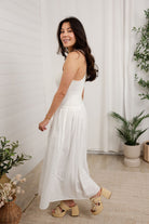 model turning to the back in white mixed media eyelet dress