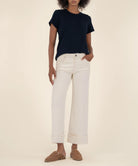 woman modeling the high rise wide leg denim with a bottom cuff in the color candle (ecru)
