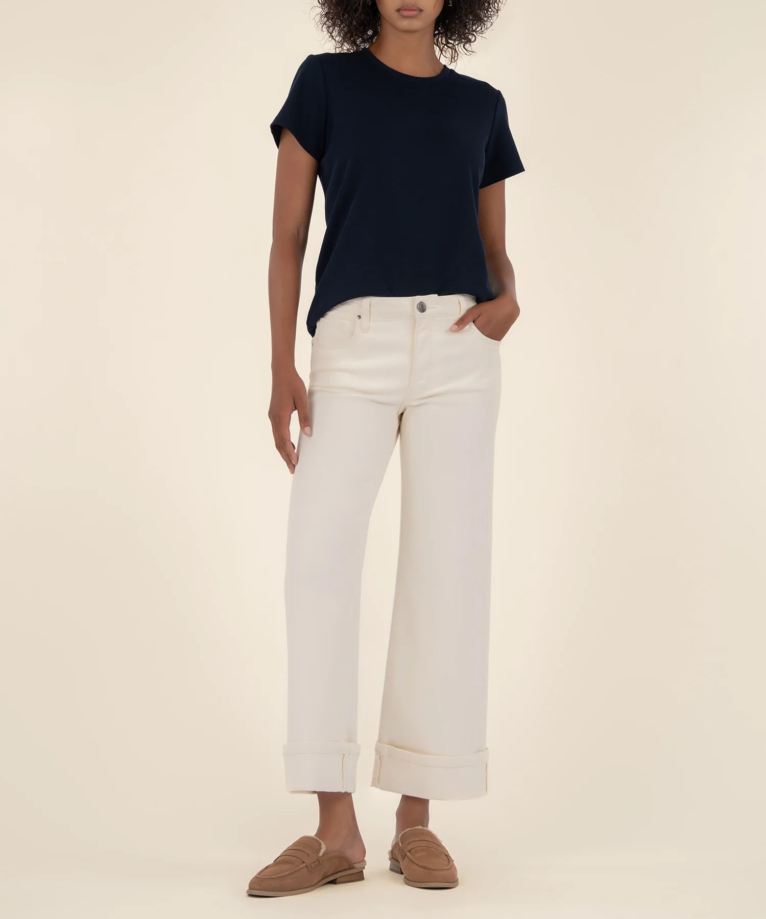 woman modeling the high rise wide leg denim with a bottom cuff in the color candle (ecru)