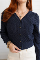 Person wearing a Pointelle Cardigan with Rose Buttons with a plain background