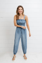 Woman wearing soft Tencel denim jumpsuit with relaxed fit and sustainable fabric from Mainstream Boutique Bloomington