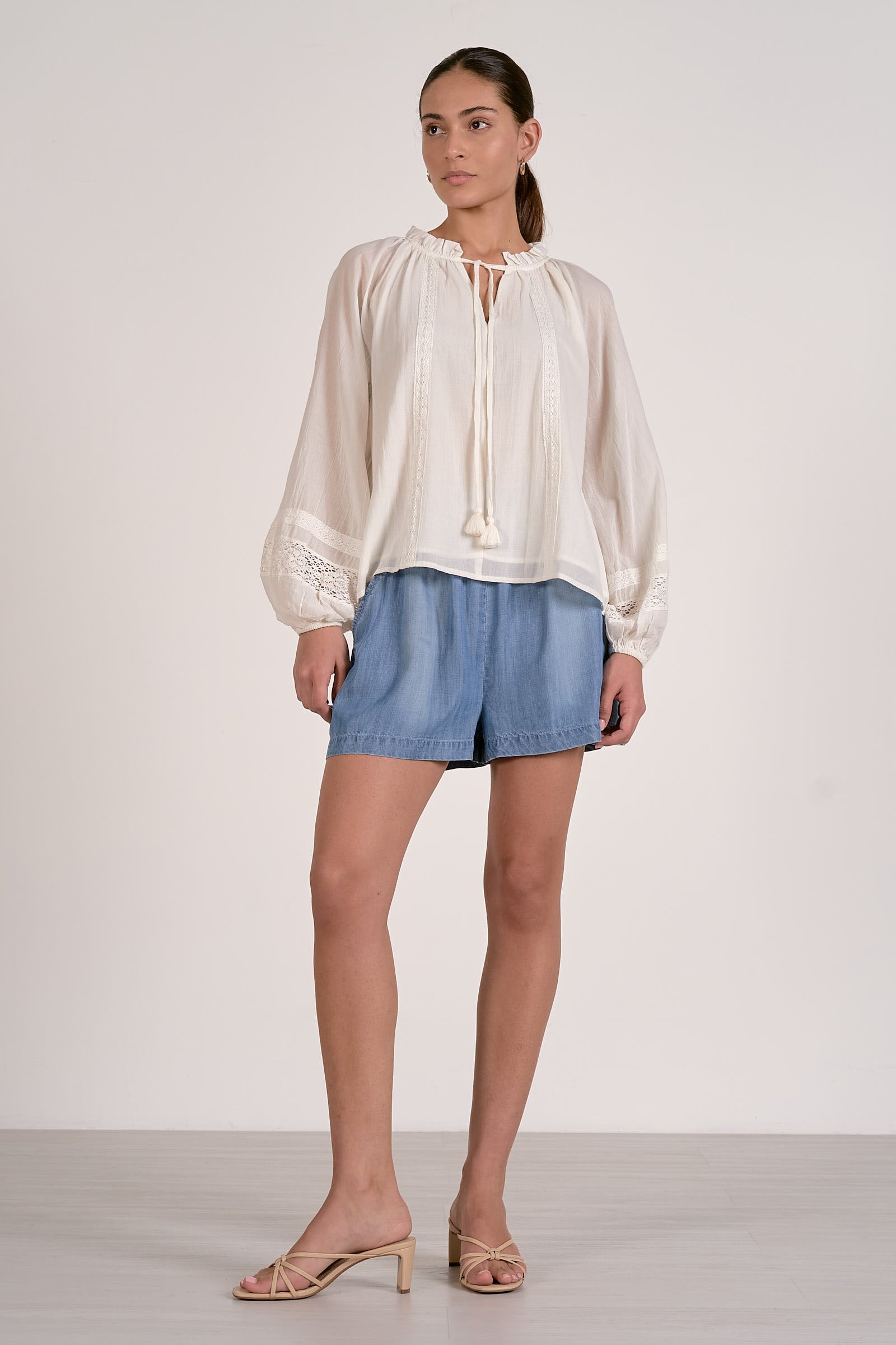 soft white airy blouse with details on sleeve and tie front with tassles