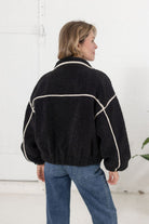 back of the black sherpa bomber jacket showing the off white corduroy detailing throughout.
