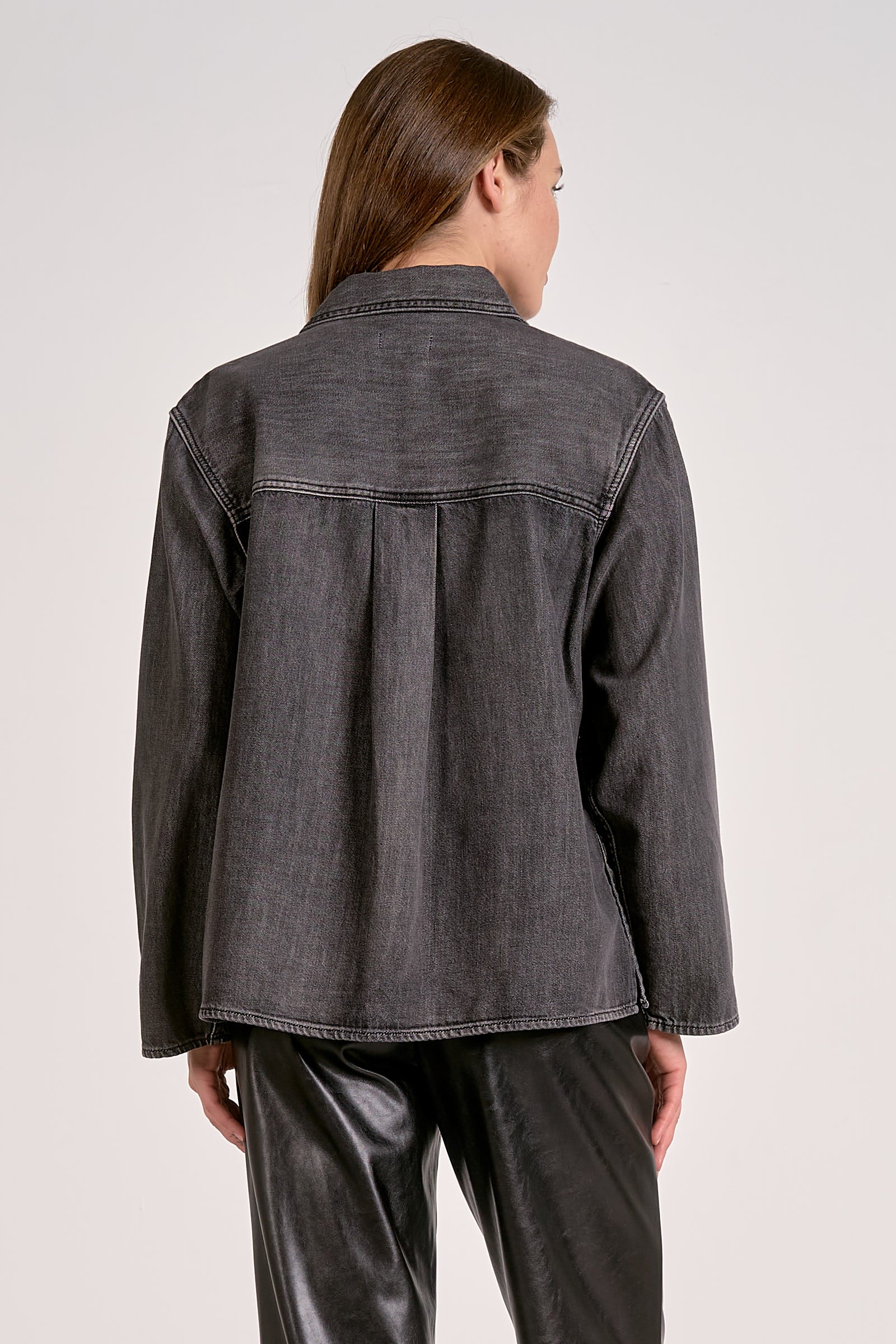 Woman showing the back view of the black wash shirt jacket