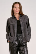 Woman showing the front view of black wash shirt jacket with silver buttons