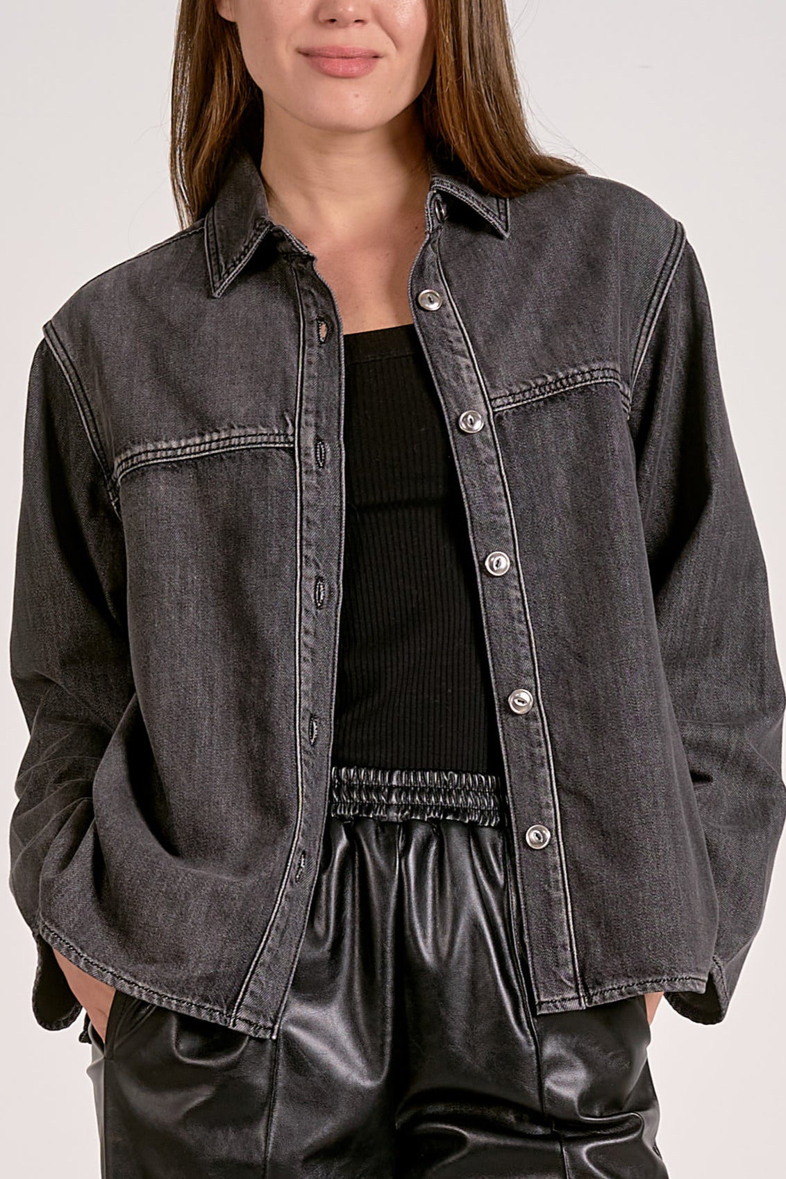 Woman showing close up of details on the front of the black wash shirt jacket