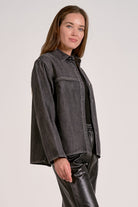 Woman showing the side view of black wash shirt jacket with silver buttons
