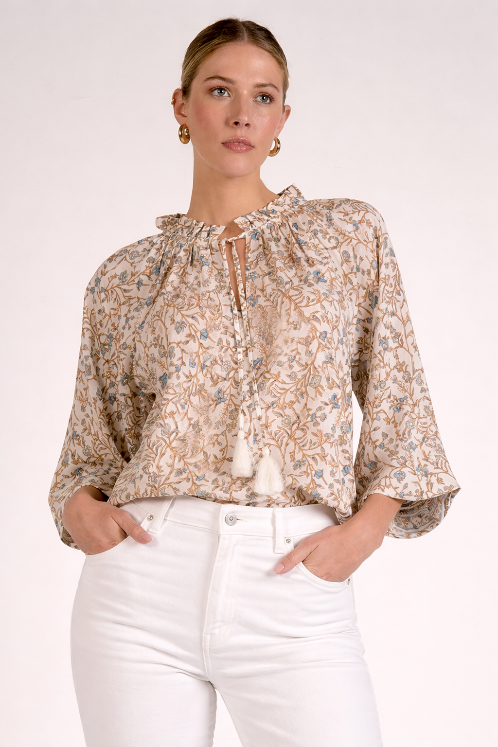 front view of blue floral print shirt with front tie tassels paired with white denim