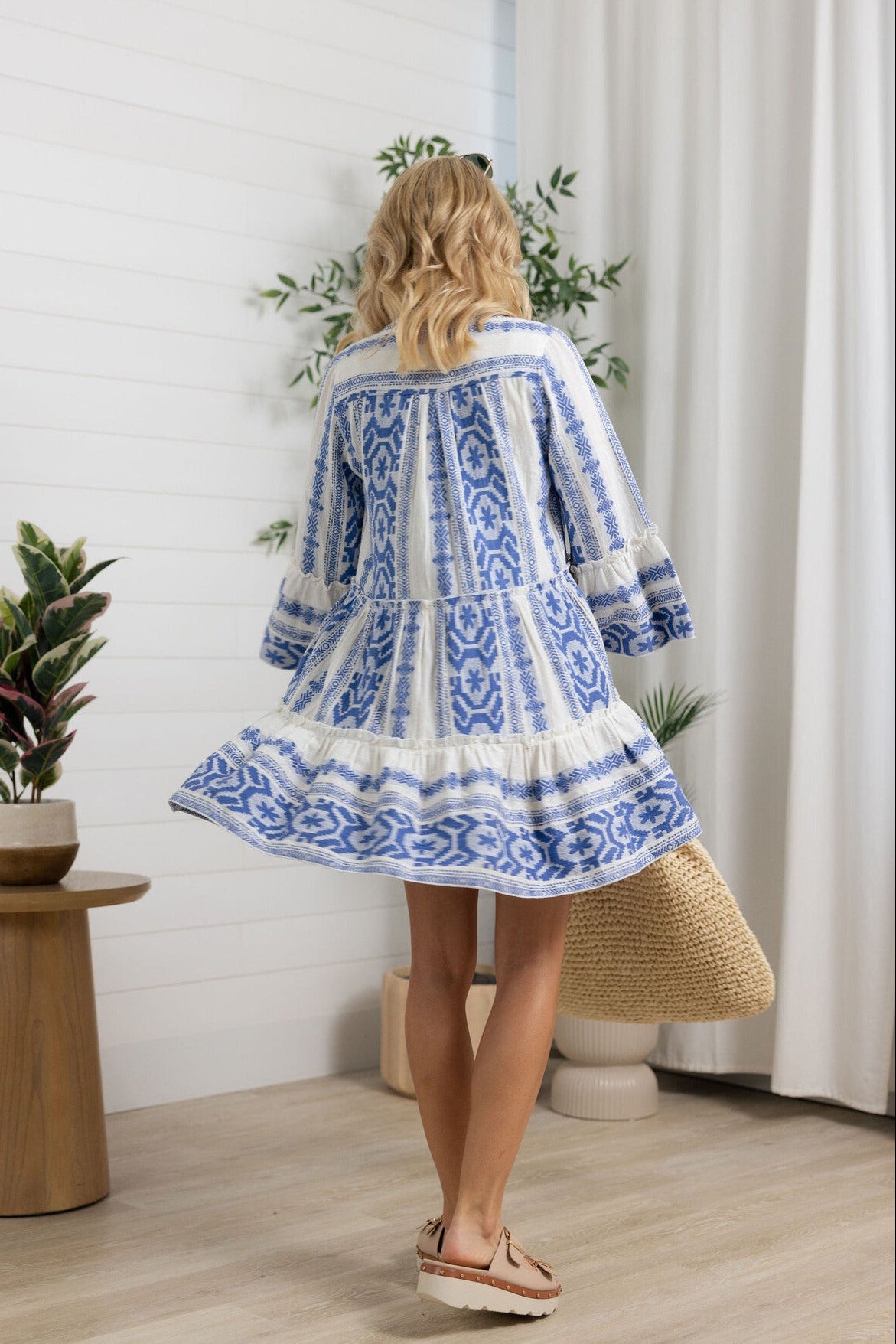 action shot of the Blue Patterned Tiered Mini Dress with Bell Sleeves