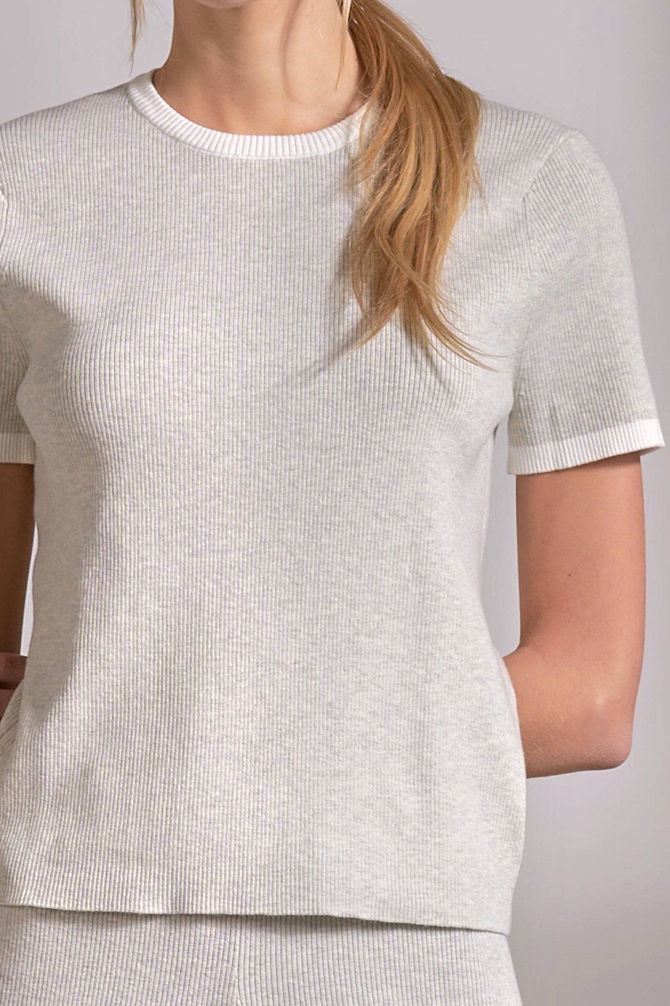 close up details on soft grey ribbed crewneck top with white stripe detail on neckline and sleeves