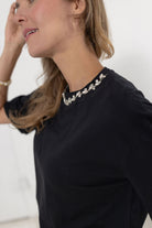 close up view of the details on the Soirée Tee in black with rhinestone embellished neckline from Mainstream Boutique Bloomington