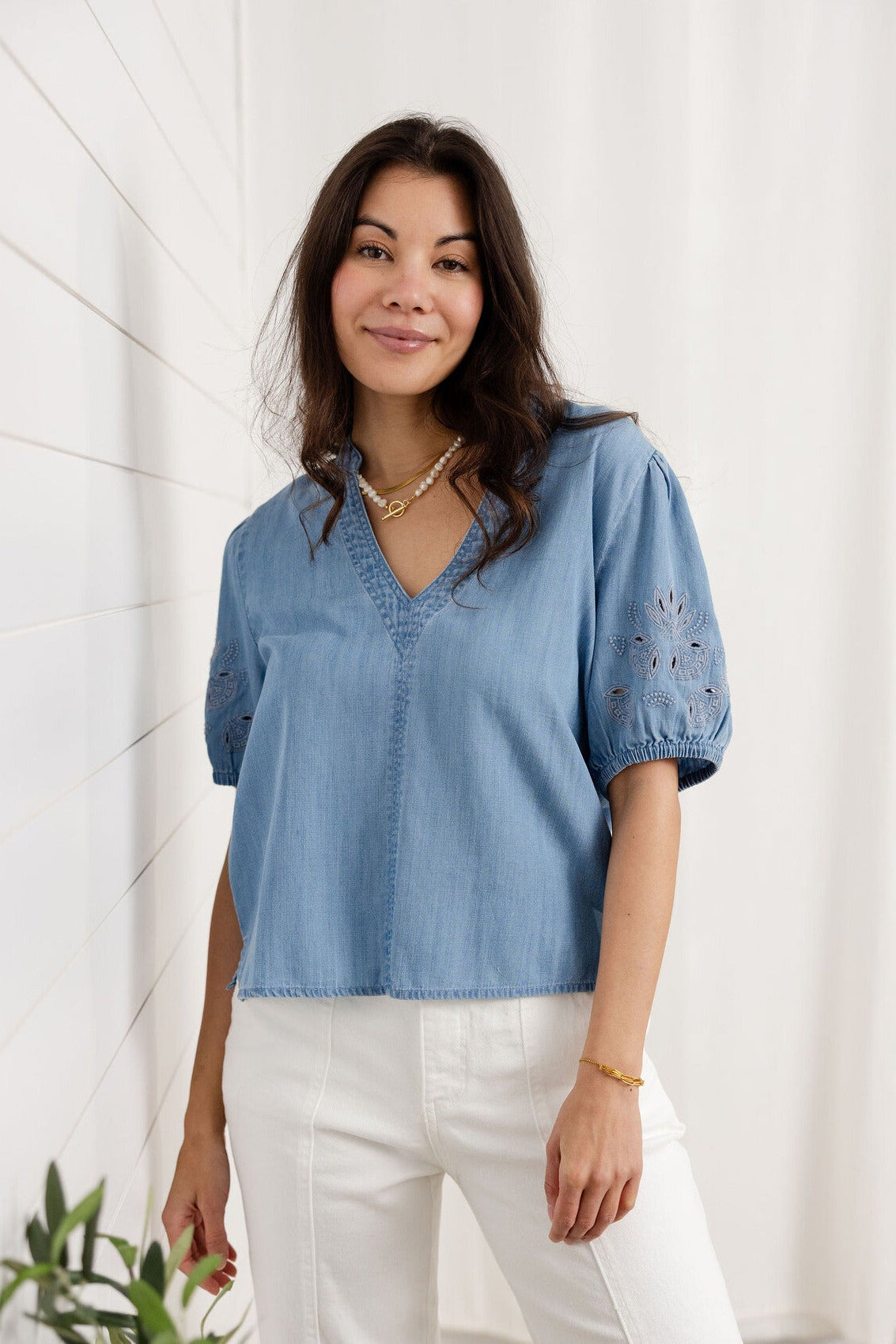 woman showing front of chambray v-neck embroidered sleeve top