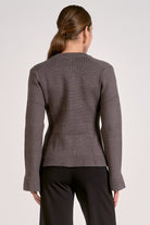 Woman showing the back view of the graphite flare cuff button cardigan front view