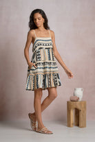Woman wearing geometric stripe tiered mini dress with adjustable spaghetti straps