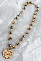 gold and bead necklace with solid coin pendant