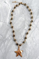 gold and bead short necklace with a solid star pendant