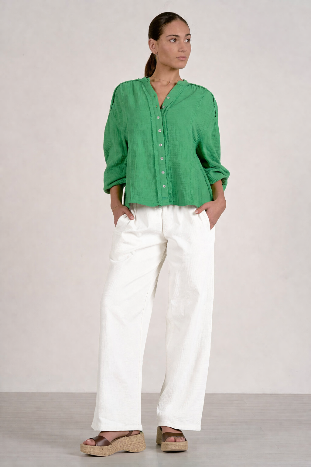 front of woman wearing kelly green gauze button front top with white bottoms