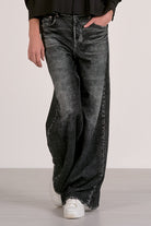 Person showing the front of the grey wash sweatpant jeans.