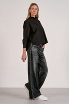 Woman showing the side of the grey wash sweatpant jeans.