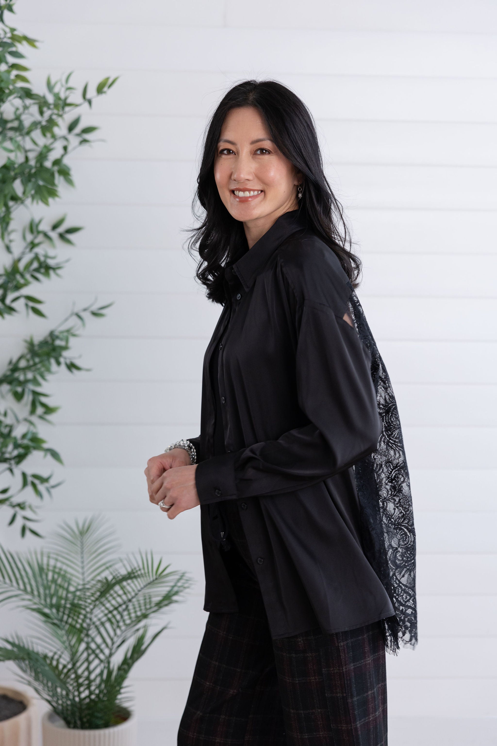 flowy movement on model of the black lace back button down showing sleek front side and lace back