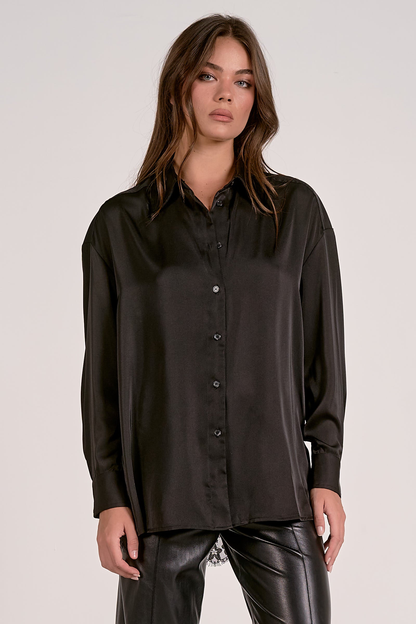 Model showing the front of the black satin button down blouse with lace back detail