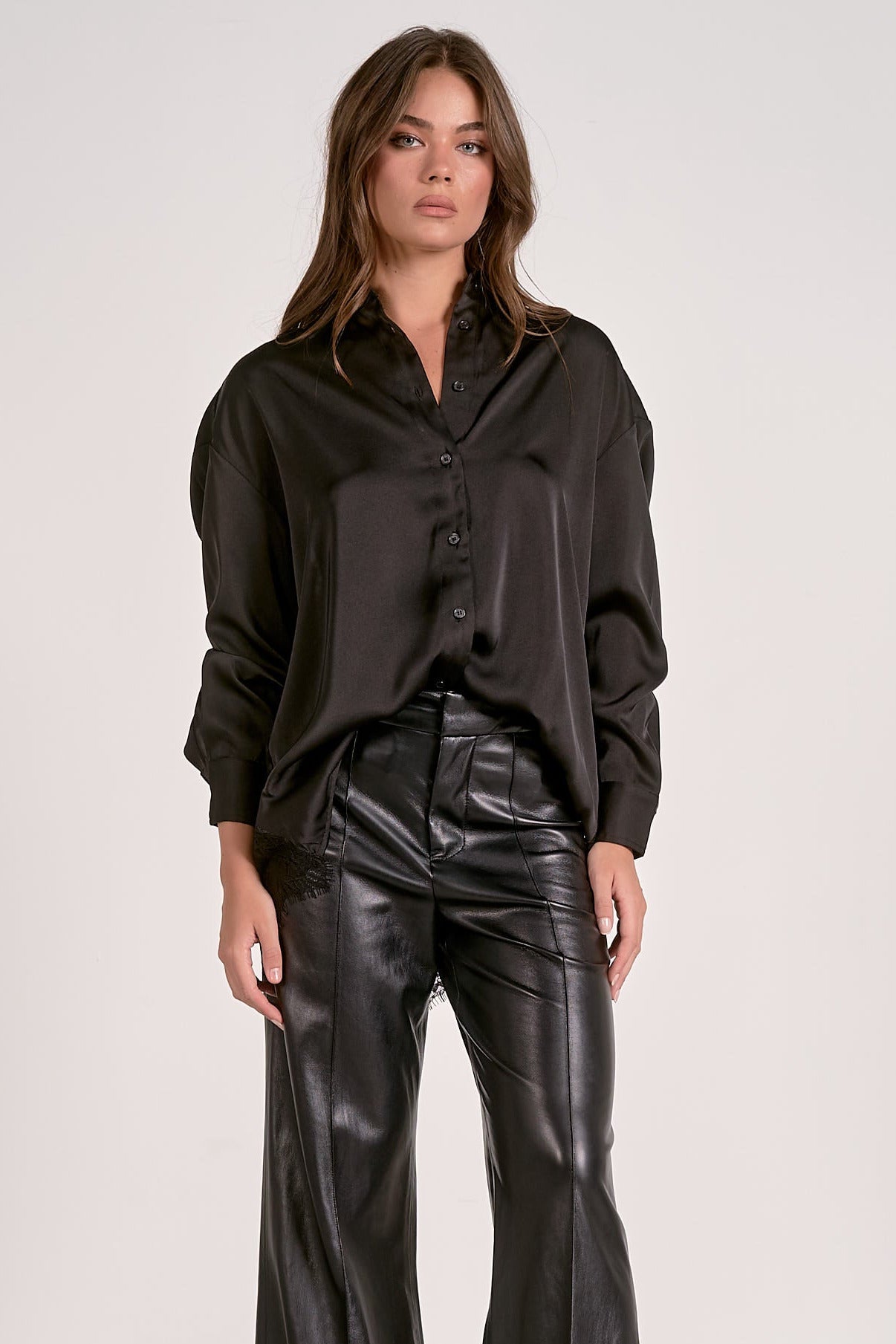 Model showing one way to style the black satin button down blouse with lace back detail