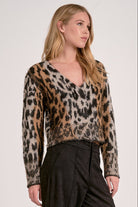 Model wearing Meet & Greet Eyelash Leopard Cardigan in fuzzy eyelash knit with leopard print and button-front closure from Mainstream Boutique Bloomington