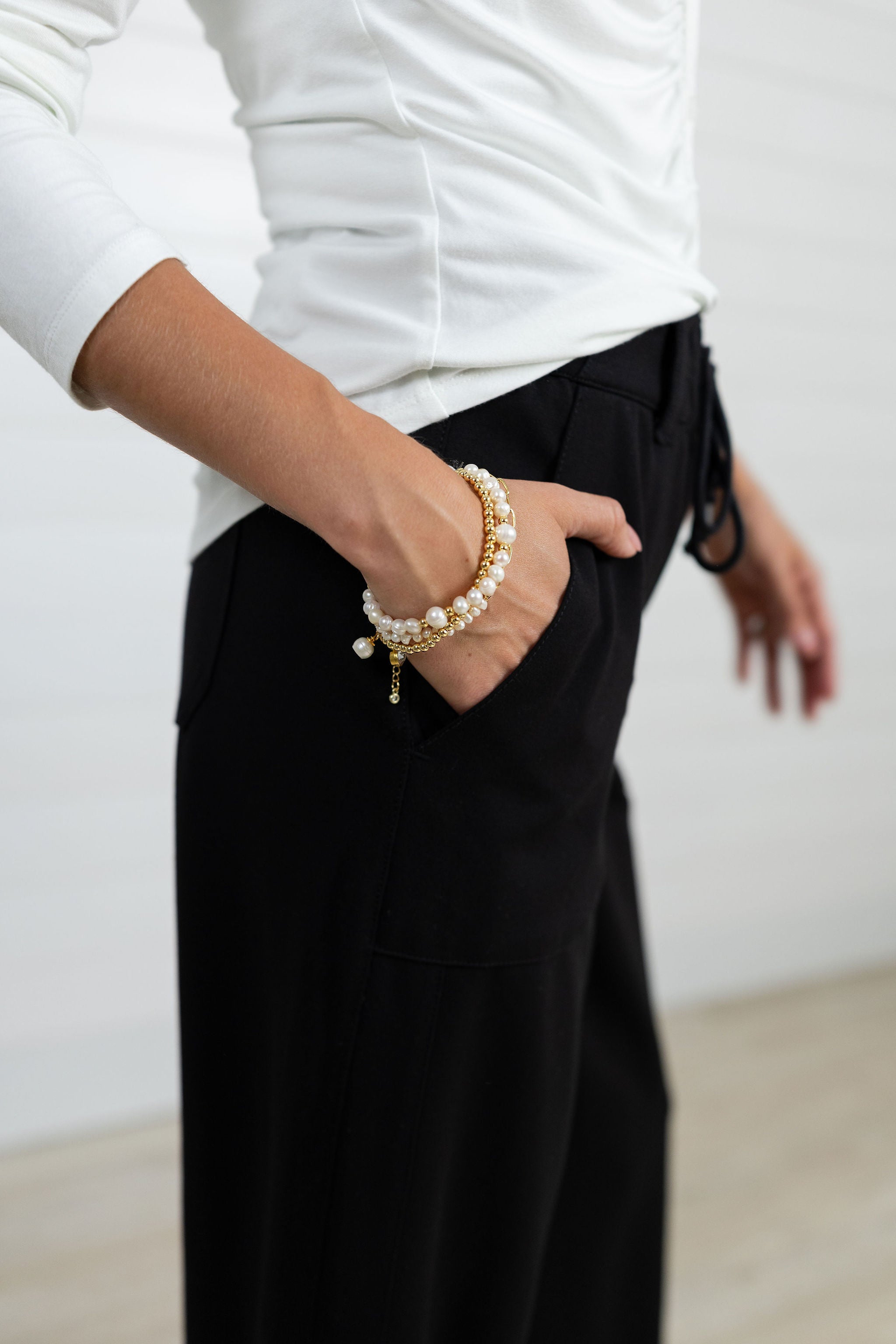 model wearing black mac and me pants with white mac and me ruuched front top