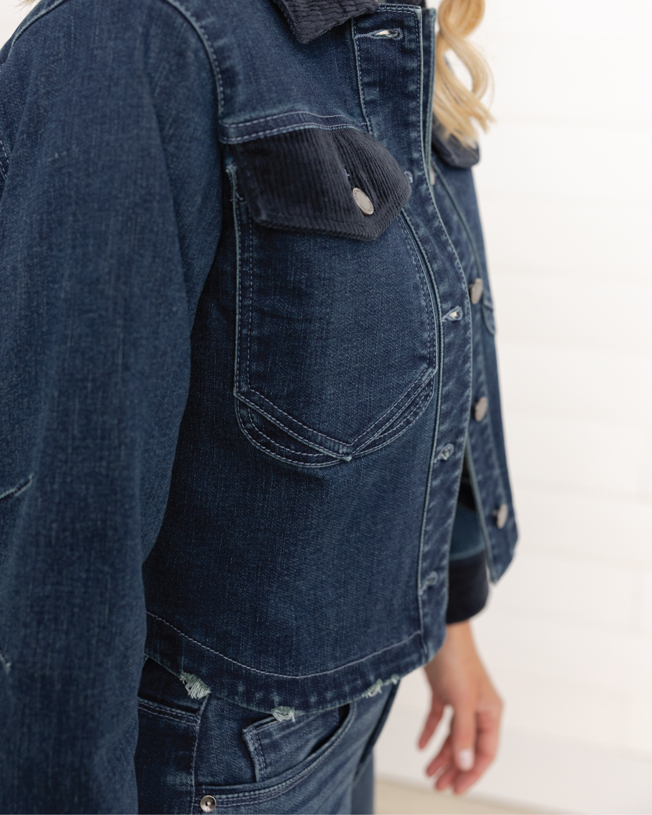 Close-up of a woman wearing Mac and Me oversized indigo denim jacket with corduroy collar and flap pockets

