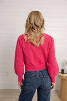 woman showing the back of the pink pointelle sweater by Mac and Me