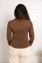 girl showing the back of the mac and me ruched front button down top in chocolate brown