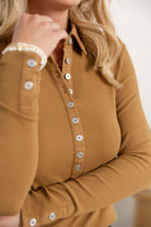 close up photo showing the mac and me ribbed henley in the color camel with pearlized buttons