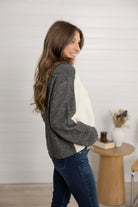 woman showing the side of the color block sweater