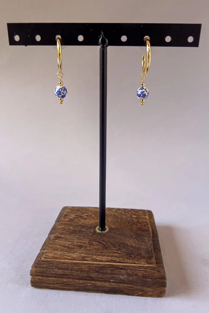 Small gold hoop earrings with blue floral porcelain bead drop