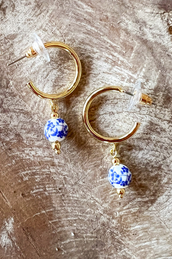 Small gold hoop earrings with blue floral porcelain bead drop