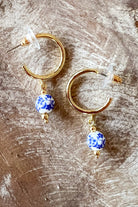 Small gold hoop earrings with blue floral porcelain bead drop