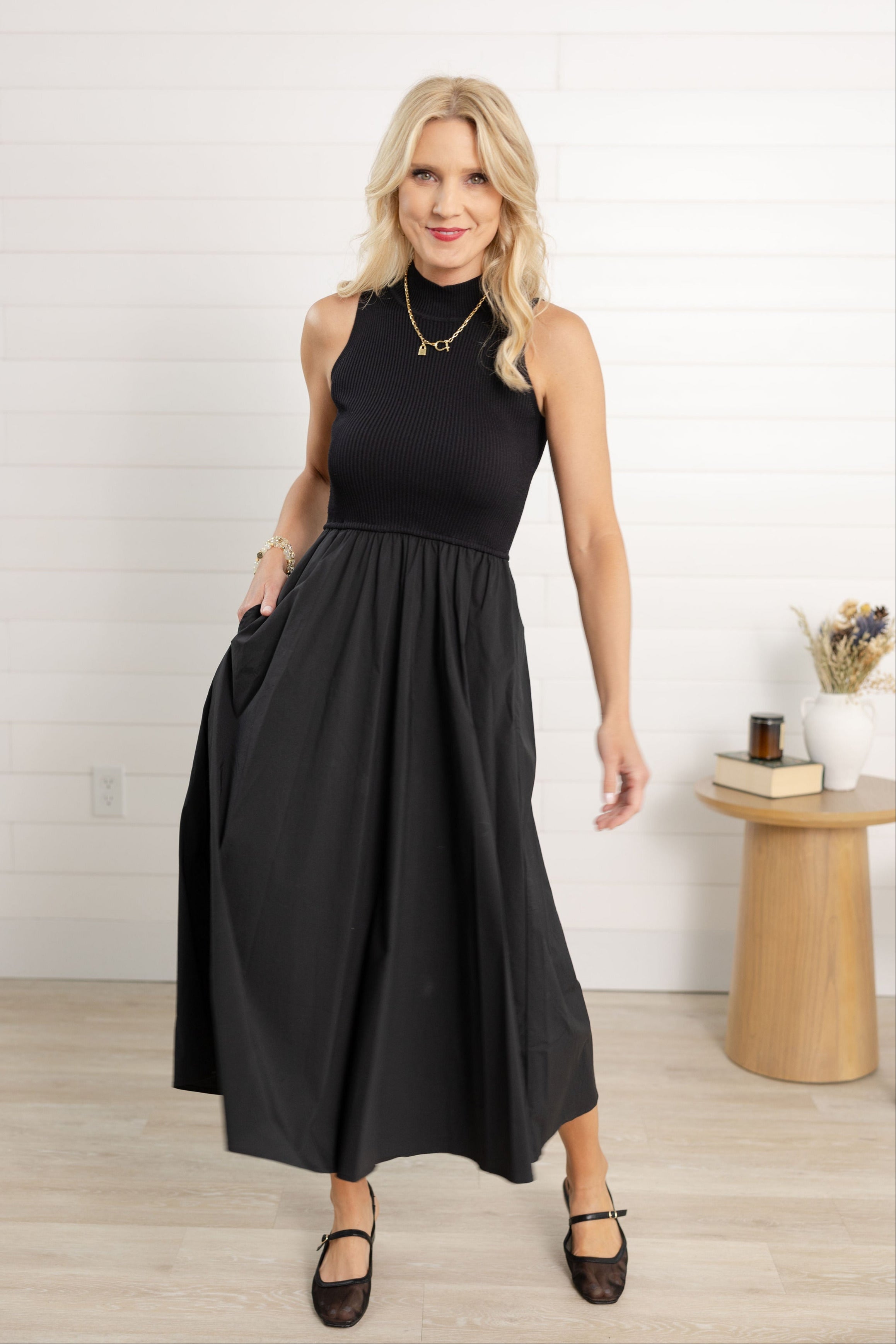 Woman modeling the black maxi mock dress sleeveless.