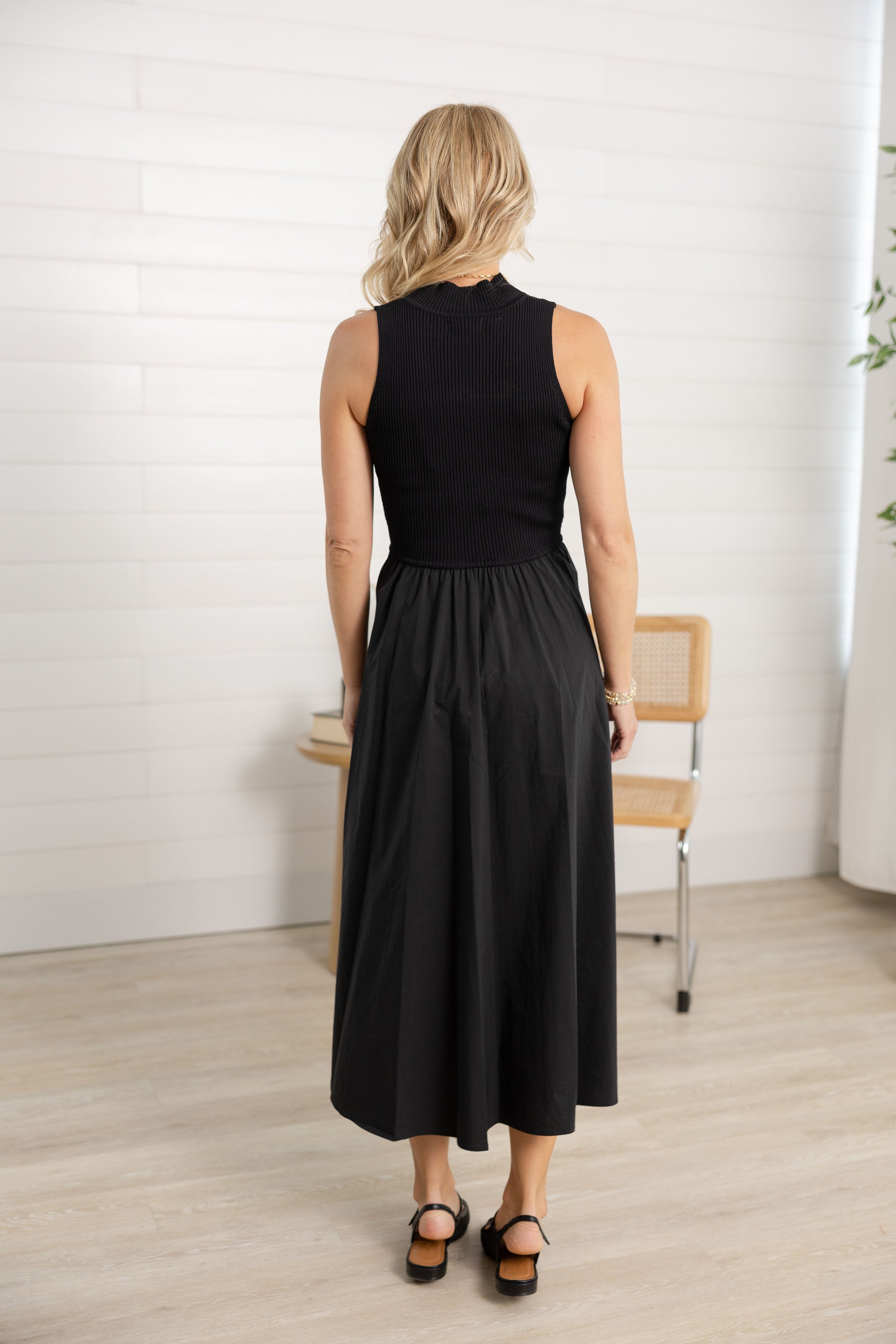 woman showing the back of the maxi mock neck sleeveless dress.