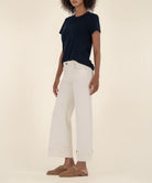woman modeling the high rise wide leg denim with a bottom cuff in the color candle (ecru)